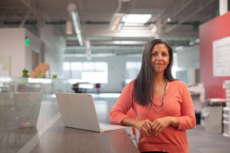 A business owner standing at a desk with a laptop